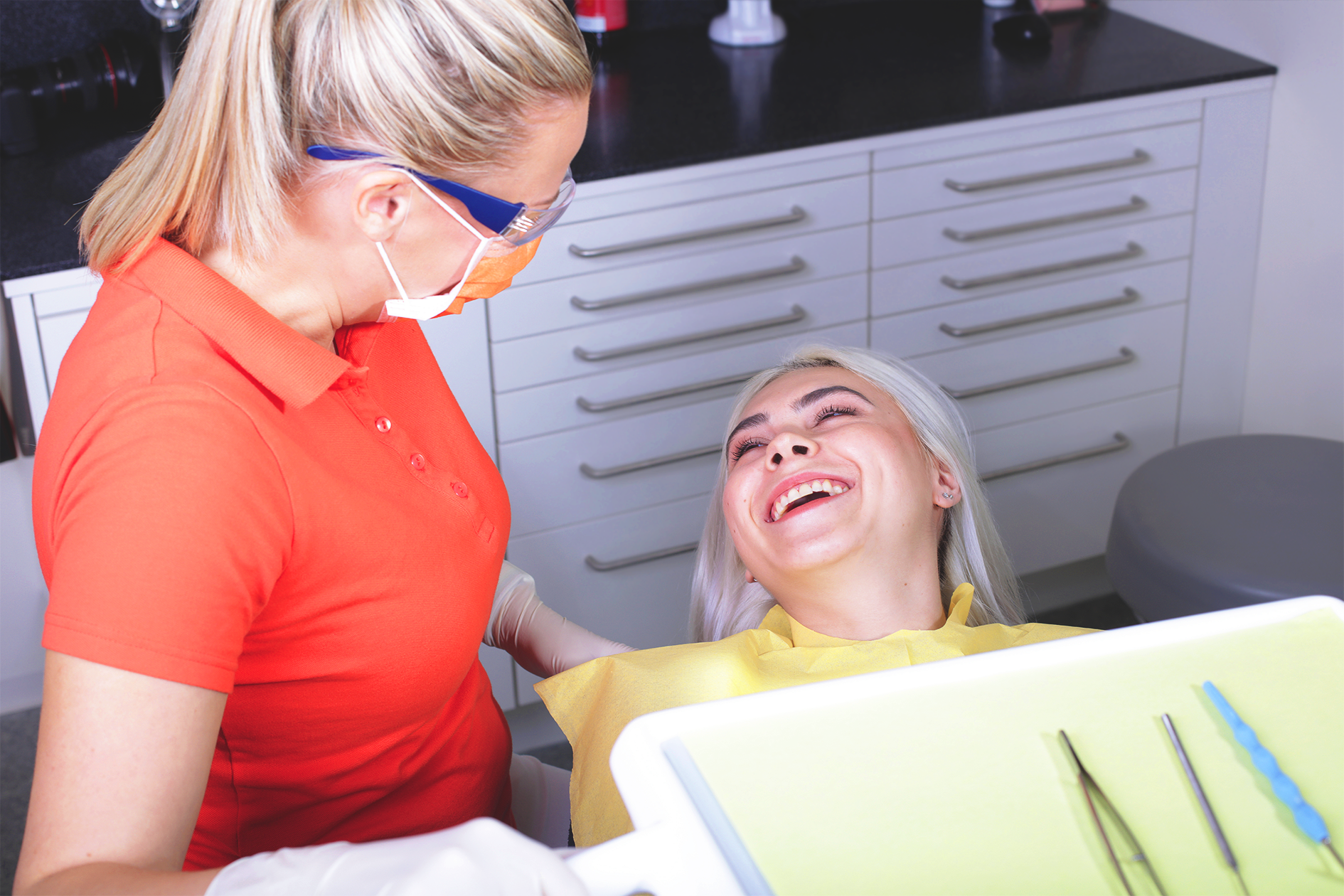 Patientin lacht mit der Zahnärztin